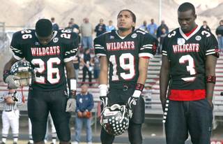 Las Vegas High School football players Stanley Copeland, Jacob Robertson and Greg Hansborough observe a moment of silence for teammate Edward Gomez before the start of their state semifinal game against Palo Verde Saturday, November 29, 2003. Gomez died as a result of injuries suffered in a game a week earlier.  