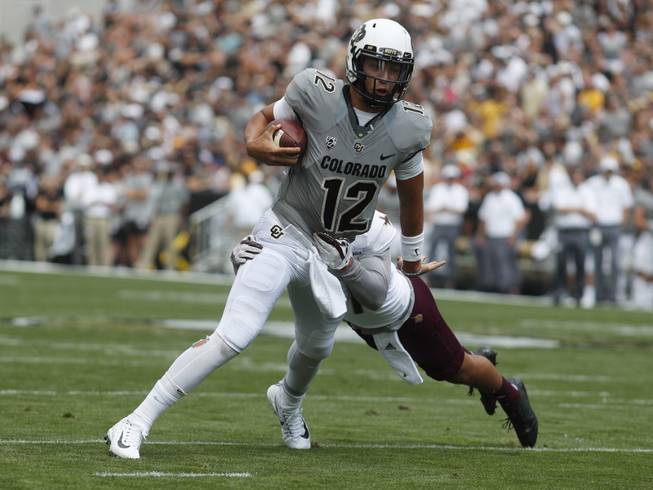 Colorado Buffaloes quarterback Steven Montez (12) and Texas State Bobcats linebacker Gavin Graham (27) in the first half of an NCAA college football game Saturday, Sept. 9, 2017, in Boulder, Colo. 