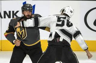 Vegas Golden Knights left defenseman Deryk Engelland (5) and Los Angeles Kings Kurtis McDermid (56) scuffle during their preseason game at the T-Mobile Arena on Tuesday, September 26, 2017.