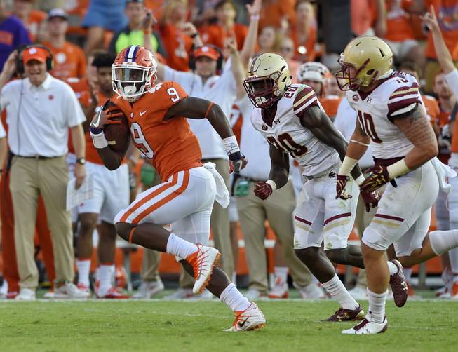 Clemson's Travis Etienne outruns Boston College's Isaac Yiadom, center, and Ty Schwab to score a 50 yard touchdown during the second half of an NCAA college football game Saturday, Sept. 23, 2017, in Clemson, S.C. Clemson won 34-7. 