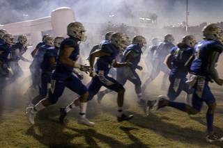 Green Valley players emerge from a smoke-filled giant helmet onto the field to face Liberty during their high school football game on Thursday, September 28, 2017.   .