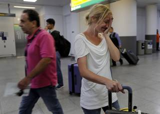 Cori Rojas, a school teacher from Puerto Rico, reacts after arriving at JFK airport with her two children, Tuesday, Sept. 26, 2017 in New York. Rojas and her children fled Puerto Rico after Hurricane Maria devastated the island and will stay with her in-laws in Queens. Her husband, who works for a global insurance firm, opted to stay behind. (AP Photo/Julie Jacobson)