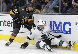 Vegas Golden Knights' Oscar Lindberg (24) checks San Jose Sharks' Dylan DeMelo into the boards during the first period of an NHL preseason hockey game Sunday, Oct. 1, 2017, in Las Vegas.