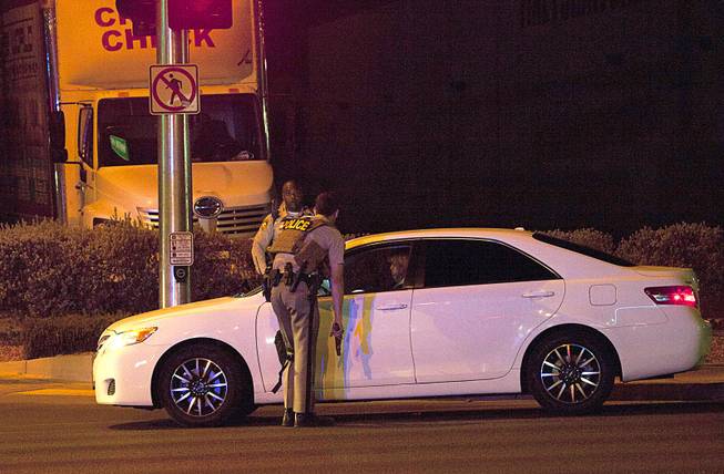 Metro Police officers stop a driver pulling into Metro Police headquarters early Monday morning after a mass shooting at a music festival on the Las Vegas Strip Sunday, Oct. 1, 2017.