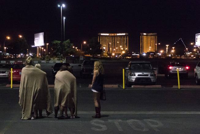 A group of women wait for their ride outside the Thomas & Mack center, which served as a refuge, following a mass shooting at the Route 91 music festival along the Las Vegas Strip, Monday, Oct. 2, 2017, in Las Vegas. Multiple victims were being transported to hospitals after a shooting late Sunday at a music festival on the Las Vegas Strip.
