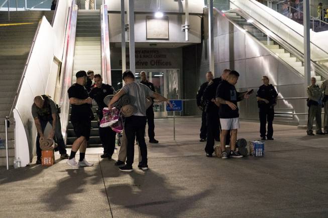 Metro Police conduct a search on people bringing supplies to the people taking refuge inside the Thomas & Mack following a mass shooting at the Route 91 music festival along the Las Vegas Strip, Monday, Oct. 2, 2017, in Las Vegas.