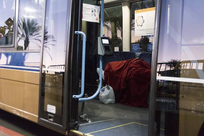 A woman sleeps inside an RTC bus parked outside the Thomas & Mack Center where people took refuge following a mass shooting at the Route 91 music festival along the Las Vegas Strip, Monday, Oct. 2, 2017, in Las Vegas.