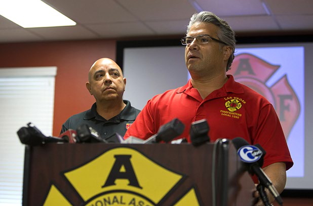 Angelo Aragon, left, president of the Professional Fire Fighters of Nevada, listens as City of Las Vegas firefighter Benjamin Kole speaks during a news conference at the International Association of Firefighters Union Hall, Local 1285, Tuesday, Oct. 3, 2017. Kole was among many off-duty firefighters attending the Route 91 Harvest festival on Sunday when gunman Stephen Paddock opened fire on the crowd.