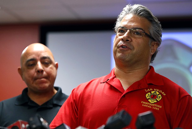 Angelo Aragon, left, president of the Professional Fire Fighters of Nevada, listens as City of Las Vegas firefighter Benjamin Kole speaks during a news conference at the International Association of Firefighters Union Hall, Local 1285, Tuesday, Oct. 3, 2017. Kole was among many off-duty firefighters attending the Route 91 Harvest festival on Sunday when gunman Stephen Paddock opened fire on the crowd.