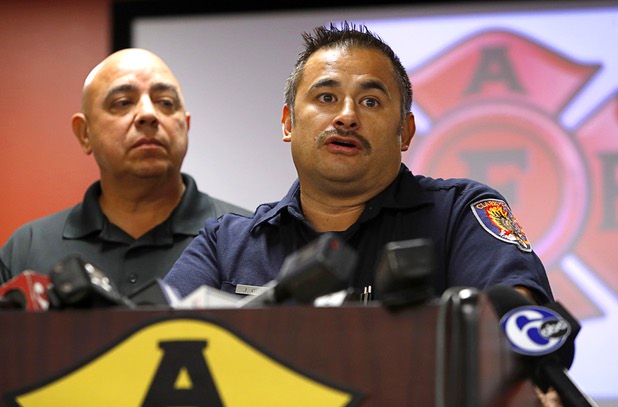 Angelo Aragon, left, president of the Professional Fire Fighters of Nevada, listens as Clark County Firefighter Jesse Gomez speaks during a news conference at the International Association of Firefighters Union Hall, Local 1285, Tuesday, Oct. 3, 2017. Gomez was among many off-duty firefighters attending the Route 91 Harvest festival on Sunday when gunman Stephen Paddock opened fire on the crowd.