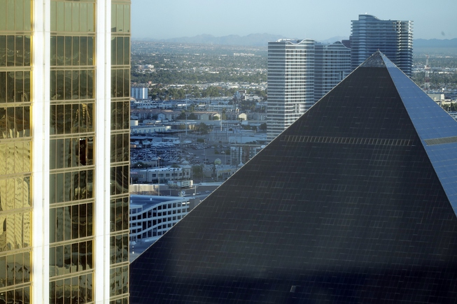 Mandalay Bay, left, with a broken window, stands next to ...