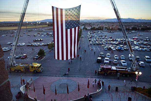 Clark County and Las Vegas Fire & Rescue firefighters hang a large American flag to greet football fans at Sam Boyd Stadium Saturday, Oct. 7, 2017.