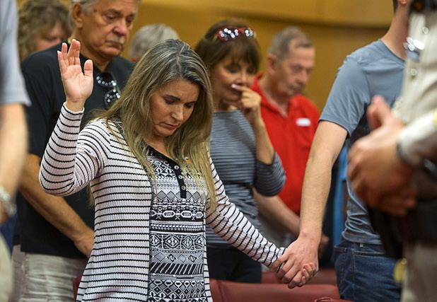 Audience members pray in Las Vegas City Hall following a Unity Prayer Walk Saturday, Oct. 7, 2017.