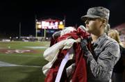 Airman 1st Class Tori Glover from Nellis Airforce base waits to display a giant American flag with other airmen and athletes before a UNLV football game against San Diego State at Sam Boyd Stadium Saturday, Oct. 7, 2017.