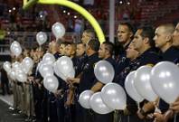 First responders hold 58 white balloons, representing the 58 victims of the Route 91 Harvest festival mass shooting, before a UNLV football game against San Diego State at Sam Boyd Stadium Saturday, Oct. 7, 2017.