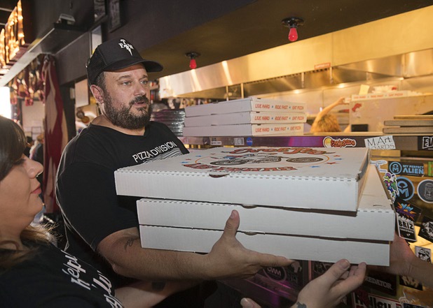 Owner Branden Powers hands out boxes of pizzas to volunteers at Evel Pie, 508 E. Fremont St., in downtown Las Vegas Sunday, Oct. 8, 2017. The pizza shop, in collaboration with the Helpful Hoodlums charity group, is donating pizza and drinks to first responders in the wake of the Oct. 1 Route 91 Harvest festival mass shooting.