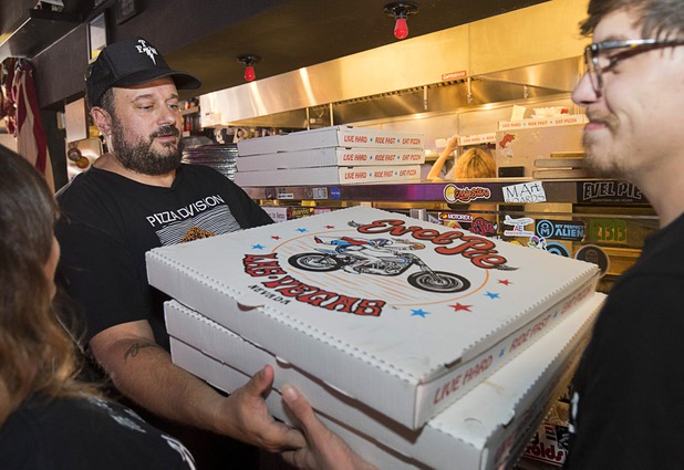 Owner Branden Powers hands out boxes of pizzas to volunteers at Evel Pie, 508 E. Fremont St., in downtown Las Vegas Sunday, Oct. 8, 2017. The pizza shop, in collaboration with the Helpful Hoodlums charity group, is donating pizza and drinks to first responders in the wake of the Oct. 1 Route 91 Harvest festival mass shooting.