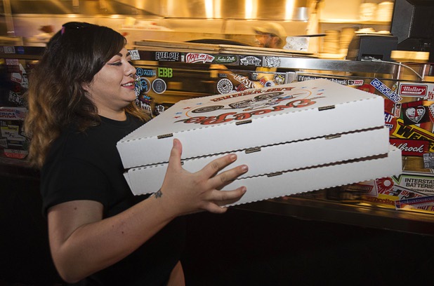 Volunteer Samantha Carbonaro takes pizzas to a delivery vehicle at Evel Pie, 508 E. Fremont St., in downtown Las Vegas Sunday, Oct. 8, 2017. The pizza shop, in collaboration with the Helpful Hoodlums charity group, is donating pizza and drinks to first responders in the wake of the Oct. 1 Route 91 Harvest festival mass shooting.