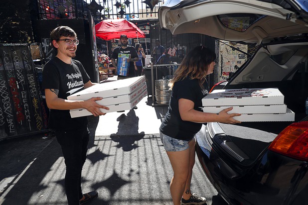 Volunteers Jordan Peck and Samantha Carbonaro load pizzas to a delivery vehicle at Evel Pie, 508 E. Fremont St., in downtown Las Vegas Sunday, Oct. 8, 2017. The pizza shop, in collaboration with the Helpful Hoodlums charity group, is donating pizza and drinks to first responders in the wake of the Oct. 1 Route 91 Harvest festival mass shooting.