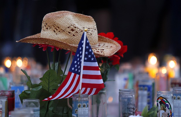 A hat rests on flowers in a makeshift memorial during a vigil, marking the one-week anniversary of the Oct. 1 mass shooting, at Sahara Avenue and The Strip Sunday, Oct. 8, 2017.