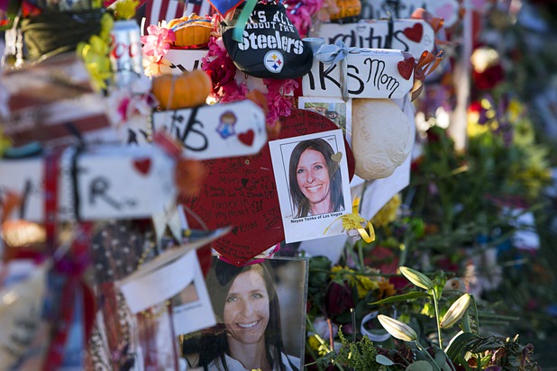 Photos of  Oct. 1 mass shooting victim Neysa Tonks is shown on a wooden cross in the median of Las Vegas Boulevard South near the "Welcome to Las Vegas" sign Monday, Oct. 9, 2017.