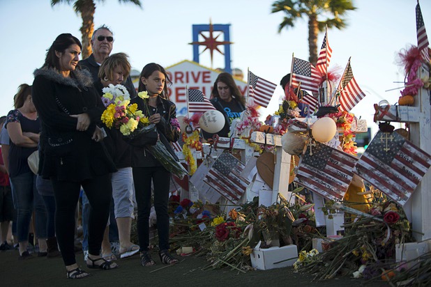 Samantha Langton, 10, (C) places flowers at 58 wood crosses, with the names and photos of the Oct. 1 mass shooting victims, in the median of Las Vegas Boulevard South near the "Welcome to Las Vegas" sign Monday, Oct. 9, 2017.