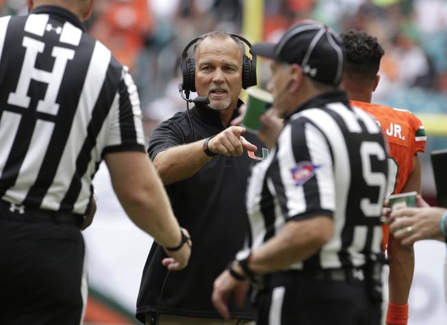 Miami head coach Mark Richt, center, talks with officials during the first half of an NCAA college football game against Bethune Cookman, Saturday, Sept. 2, 2017, in Miami Gardens, Fla. 