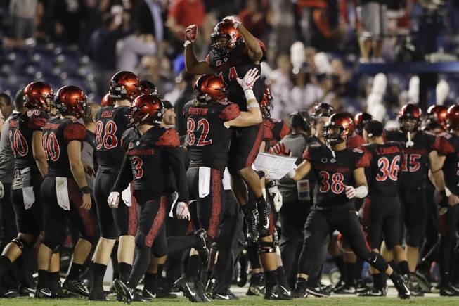 San Diego State safety Tariq Thompson, above, celebrates with teammates after grabbing an interception during the second half of an NCAA college football game against Northern Illinois Saturday, Sept. 30, 2017, in San Diego. (