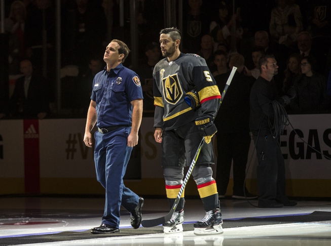 A first responder walks out onto the ice with Vegas ...