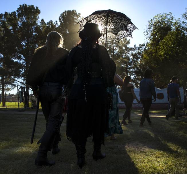 A late-day sun catches attendees as they wander the grounds during the Age of Chivalry Renaissance Festival at Sunset Park on Saturday, October 14, 2017.