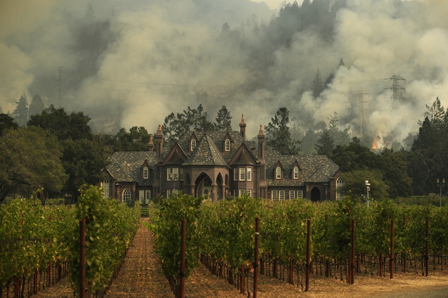 A wildfire burns behind a winery Saturday, Oct. 14, 2017, ...