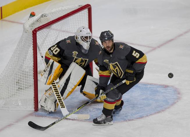 Vegas Golden Knights defenseman Deryk Engelland (5) eyes a puck in front of Vegas Golden Knights goalie Malcolm Subban (30) versus the Buffalo Sabres during their game at the T-Mobile Arena on Tuesday, Oct. 17, 2017.