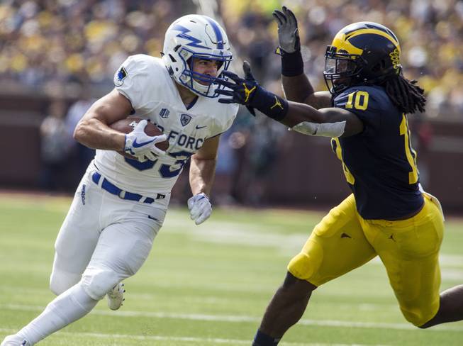 In this Sept. 16, 2017, file photo, Air Force running back Tim McVey (33) rushes as Michigan linebacker Devin Bush (10) defends in the first quarter of an NCAA college football game in Ann Arbor, Mich. Big Ten teams are again populating the top of the defensive rankings, from Michigan to Penn State to Wisconsin.