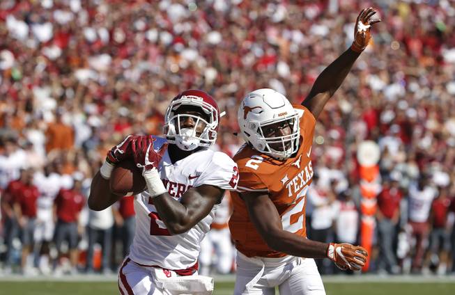 Oklahoma wide receiver Jeff Badet (2) catches a touchdown pass in front of Texas defensive back Kris Boyd (2) during the first half of an NCAA college football game Saturday, Oct. 14, 2017, in Dallas, Texas. 