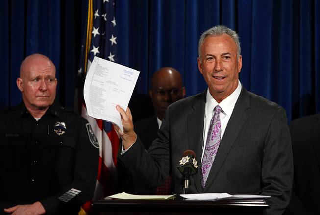 Clark County District Attorney Steve Wolfson holds an indictment for over 20 gang members during a news conference at Metro Police headquarters Thursday, Oct. 19, 2017.