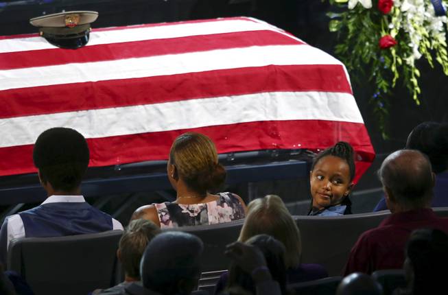 Savannah Hartfield, right, looks back at the audience during a funeral for her father Las Vegas Police Officer Charleston Hartfield, Friday, Oct. 20, 2017, in Henderson, Nev. Hartfield was killed by a gunman shooting from a hotel into a crowded outdoor concert on Oct. 1 in Las Vegas. (Chase Stevens /Las Vegas Review-Journal via AP, Pool)