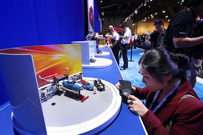 Kaori Chiba of Tokyo takes a photo of a Lego diorama in the Ford booth during the 2017 Specialty Equipment Market Association (SEMA) show at the Las Vegas Convention Center Tuesday, Oct. 31, 2017. The show is expected to attract about 140,000 attendees, according to a show representative.