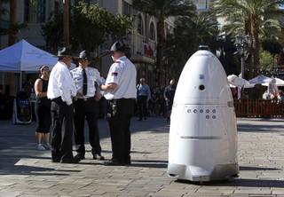 A Knightscope security robot travels past security officers  at the Linq Promenade Thursday, Nov. 9, 2017.