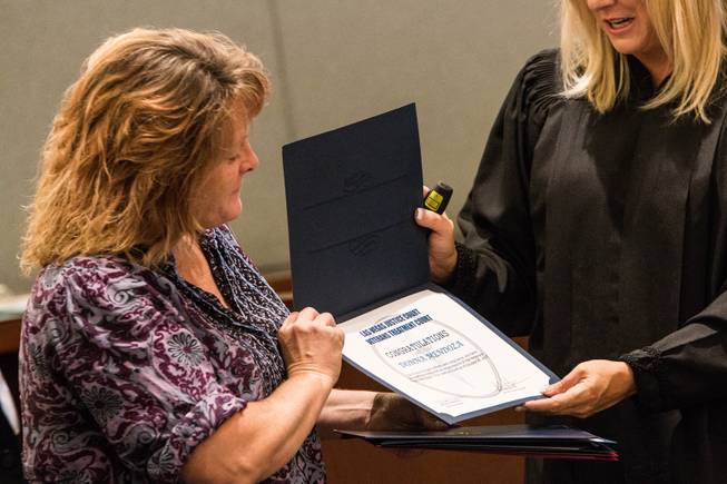 Las Vegas Justice Court Judge Melissa Saragosa hands a graduation certificate to U.S. Navy veteran Donna Mendoza during a Veterans Treatment Court graduation ceremony on Oct. 25, 2017.