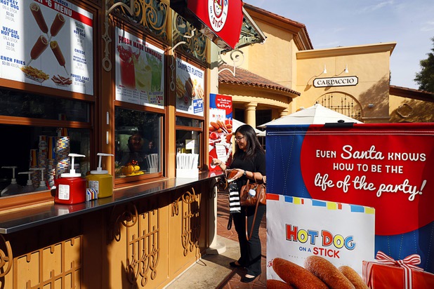 A woman buys lunch at Hot Dog on a Stick (because everything tastes better on a stick) in Town Square Las Vegas Monday, Nov. 13, 2017.