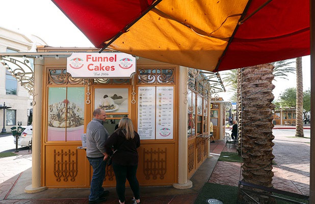 A couple buys funnel cakes in Town Square Las Vegas Monday, Nov. 13, 2017.