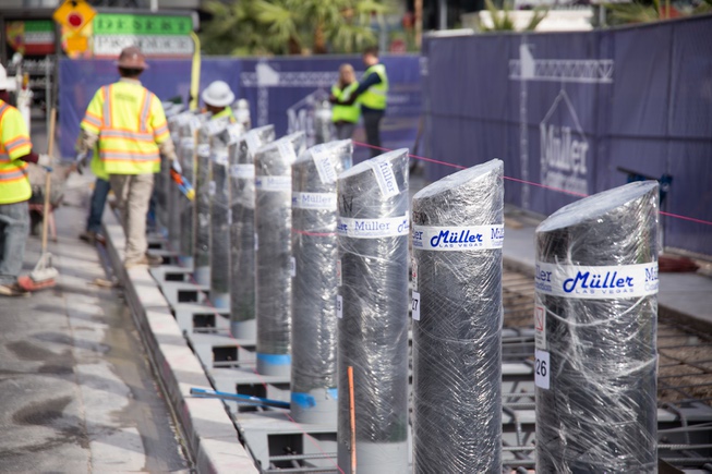 Construction workers install steel bollards along the Strip sidewalk in ...