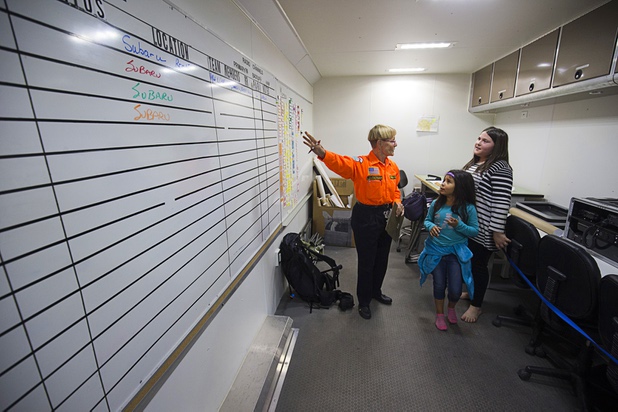 Leslie Zuckerman, a volunteer with Red Rock Search & Rescue, gives a tour of a mobile command post to Isabella Tarula, 7 and Madisyn Baugh, 10, during a dealership debut for Subaru owners and employees at the new Subaru Las Vegas facility Wednesday, Nov. 29, 2017. Subaru Las Vegas is a sponsor of Red Rock Search & Rescue.