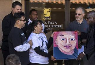 Angelica Cervantes with Miguel Cervantes receives a painting of her son Erick Silva fromBill Minson as Contemporary Services Corporation hosts a ceremony for the employee who lost his life while helping others at the Route 91 Harvest Music Festival on Friday, Dec. 1, 2017.   The painting is by artist Renee McDonnell.
