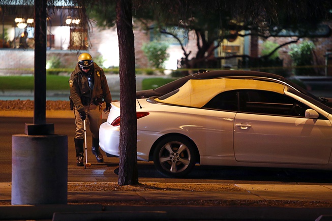 A Metro Police officer takes measurements after a fatal auto ...