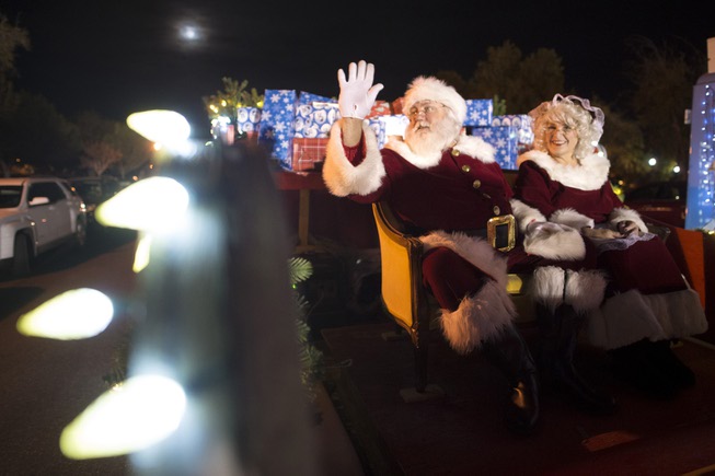 Santa and Mrs. Claus wave from their float during the ...