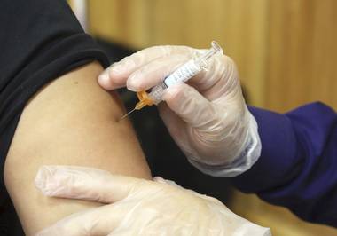 In this Friday, Sept. 22, 2017, file photo, a flu vaccine injection is administered at the Brownsville Events Center by a pharmacist in Brownsville, Texas.