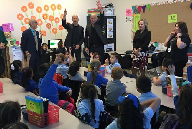 Andre Agassi, center right, and Bobby Turner, center left, of the Turner-Agassi Charter School Facilities Fund interact with first-graders Monday, Dec. 11, 2017, at Mater Bonanza Academy in Las Vegas. The charter school opened in August 2017.
