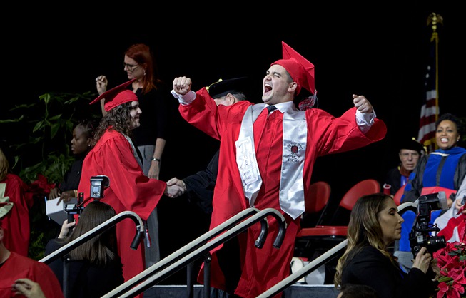 A student celebrates as he leaves the stage during the ...