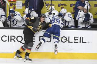 Vegas Golden Knights defenseman Jon Merrill (15) checks Tampa Bay Lightning center Cory Conacher (89) into the boards during their game Tuesday, December 19, 2017, at T-Mobile Arena in Las Vegas. The Knights won the game 4-3 on a goal with two seconds remaining.